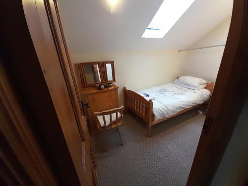 a small bedroom with a bed and a skylight at Moira Barn At Berwickhall in Moira