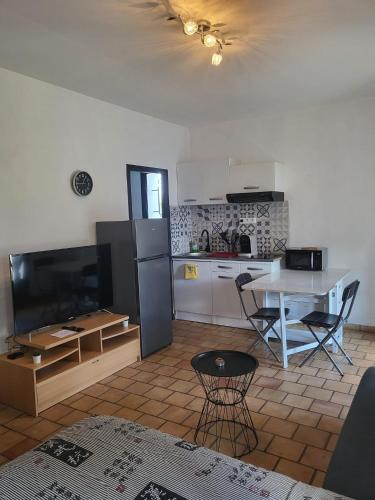 a kitchen with a table and a kitchen with a table and a table at Studio en pleine campagne in Le Thor