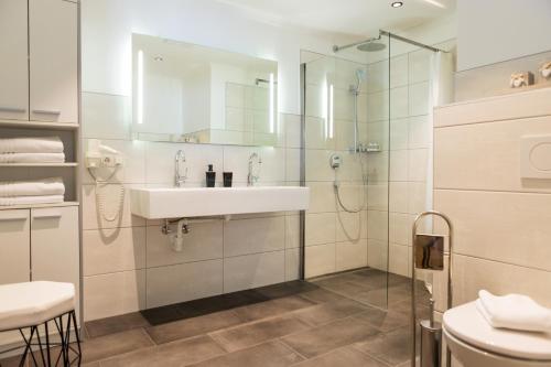 een badkamer met een wastafel en een glazen douche bij Apartments Mooshof in Neustift im Stubaital