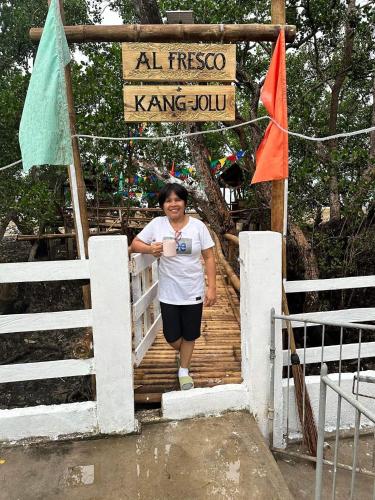 a woman walking down a wooden stairs with a sign at Kang-JoLu's Camotes Homestay in Camotes Islands
