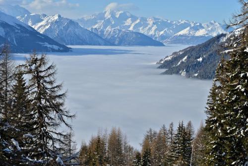 a view of a lake with snow covered mountains at Hotel Bellwald in Bellwald