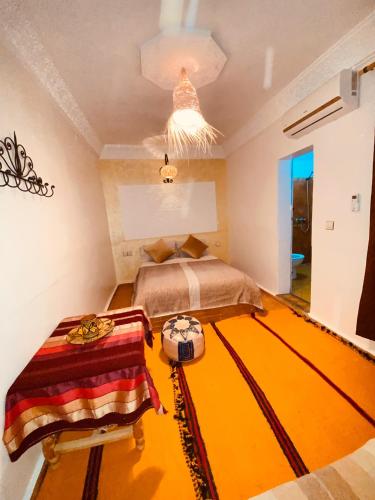 a bedroom with a large orange rug on the floor at Auberge Tissadrine in Akhendachou nʼAït Ouffi