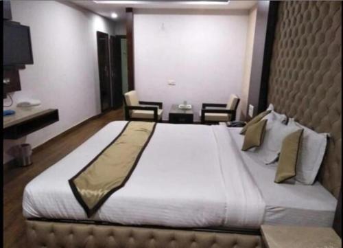 a large bed in a hotel room with chairs at hotel puneet international in Raipur