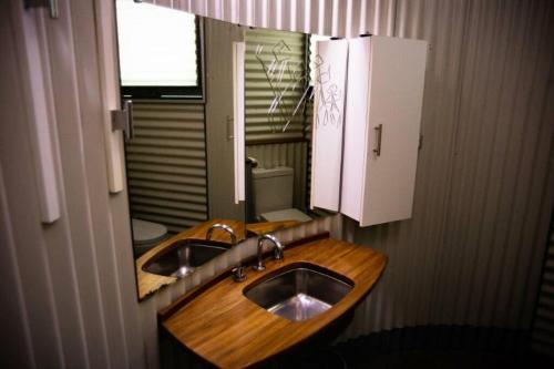 een badkamer met een houten wastafel en een spiegel bij The Shedhouse at Milbrodale Farm in Bulga
