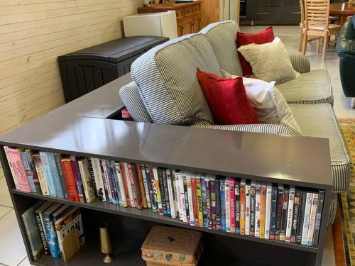 a book shelf full of dvds next to a couch at The Shedhouse at Milbrodale Farm in Bulga