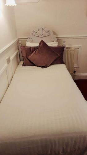a white bed with two pillows on top of it at The Bull Hotel in Horncastle