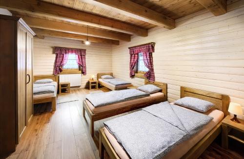 um quarto com três camas num chalé de madeira em Chalupa Grúnik em Jezersko
