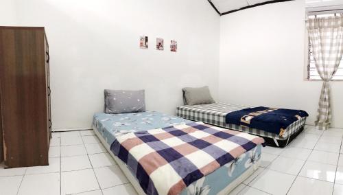 a room with two beds in a room at Dehome near Pakuwon Mall in Surabaya