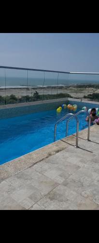 a swimming pool with blue water and volley balls at Apartment by the sea in Puerto Colombia
