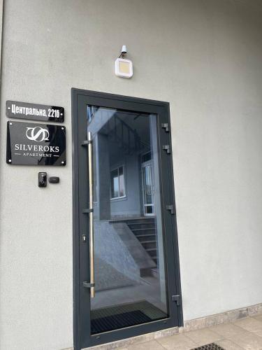 a door to a building with a sign on it at Silveroks Apartment in Prilimanskoye