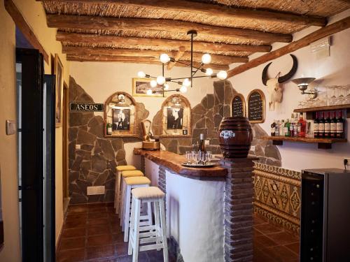 a bar in a restaurant with a stone wall at Mesón La Hospedería in Cómpeta