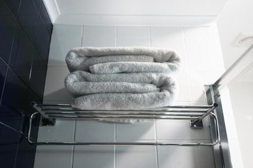 einen Haufen Handtücher, die auf einem Regal im Bad liegen in der Unterkunft Oleiros Rooms City Center in Coimbra