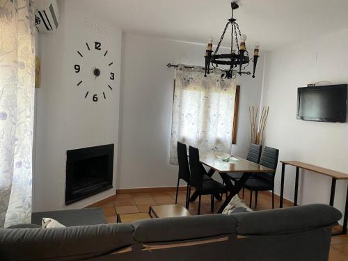 a living room with a couch and a clock on the wall at Cabañas De Madera Y Bungalows - Gilmañas 3 in La Iruela