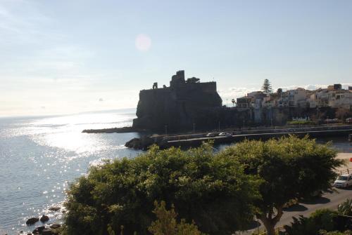 a view of the ocean and a beach with buildings at Casa Il Delfino in Aci Castello