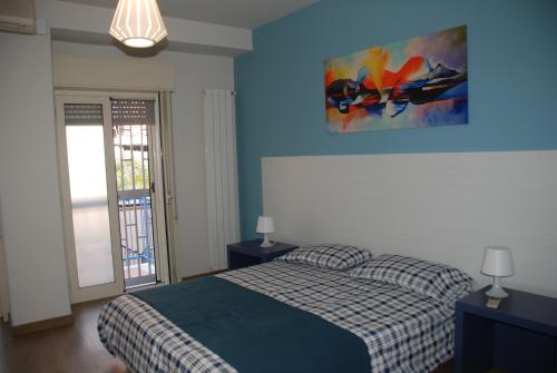 a bedroom with a bed and a painting on the wall at Casa Il Delfino in Aci Castello