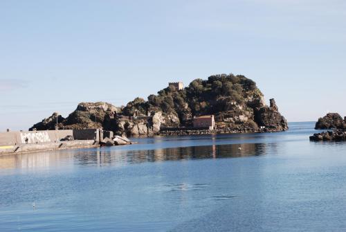 an island in the middle of a body of water at Casa Il Delfino in Aci Castello