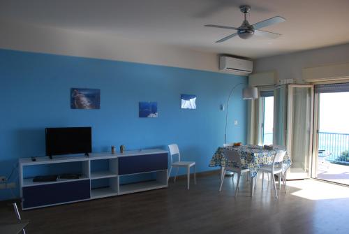 a blue living room with a table and a television at Casa Il Delfino in Aci Castello