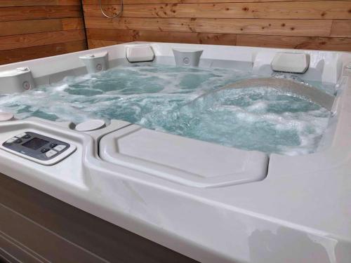 uma banheira jacuzzi com um líquido verde em Loft privatisé avec spa XXL et piscine chauffée em Bruz