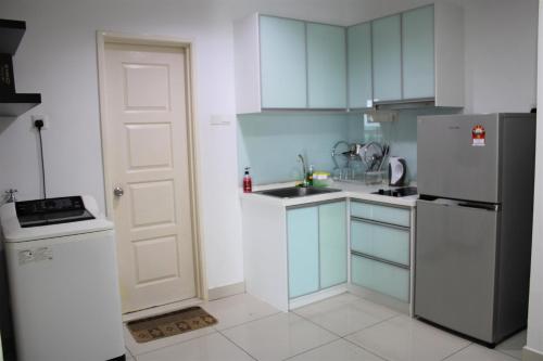 a kitchen with blue cabinets and a white refrigerator at Mansion One SeaView Georgetown 2BR 6 Pax in George Town