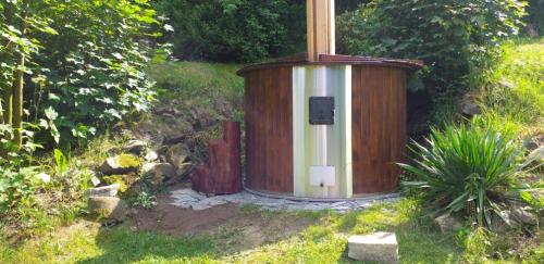 a wooden outhouse in a garden in the grass at Chalupa Hořice na Šumavě in Hořice na Šumavě