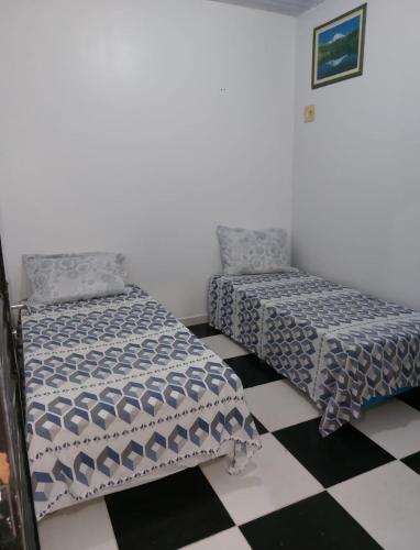 2 camas en una habitación con suelo a cuadros en Apto próx Aeroporto, en Manaus