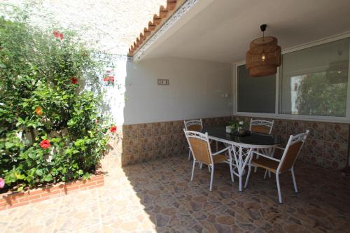 洪達海灘的住宿－Adosado La Salada by Rental Olé，庭院配有桌椅和植物