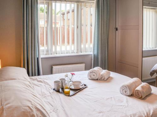 uma cama com uma bandeja de comida e toalhas em Peace Haven em Gorleston-on-Sea