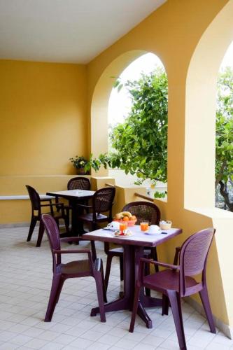 a restaurant with tables and chairs and two windows at Affittacamere Casa del Sole in Cala Gonone