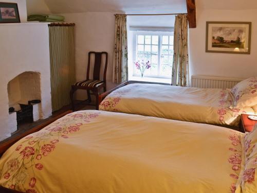 2 camas en una habitación con ventana en The Old Post Office, en Yellowham Wood