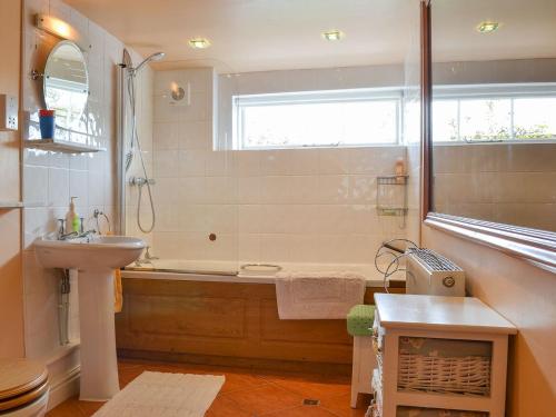 a bathroom with a bath tub and a sink at Bugatti House in Bosbury