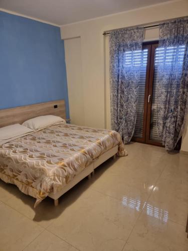 a bedroom with a bed and a large window at B&B Azzurro in Padula