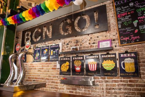 a bar with signs on a brick wall at Urbany Hostel BCN GO! in Barcelona