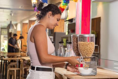 a woman is preparing food in a blender at Urbany Hostel BCN GO! in Barcelona