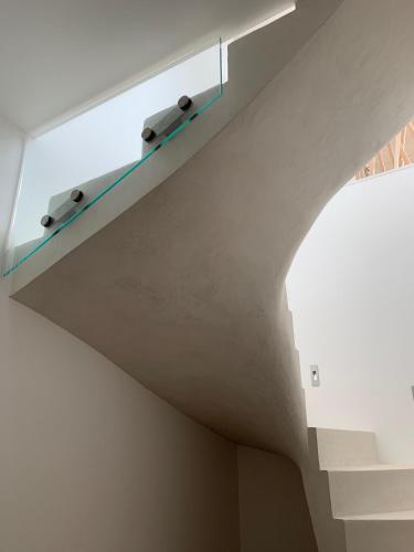 un escalier avec une étagère bleue sur un mur blanc dans l'établissement Villa prestige U Scogliu- Erbalunga, à Brando
