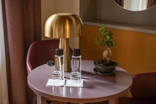a table with a lamp and two glasses on it at Castel Sant Angelo Luxury Rooms and Tour in Rome