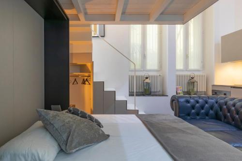 a bedroom with a bed and a couch and stairs at Golden Prestige in Milan
