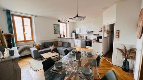 sala de estar con mesa y sofá en Charmant appartement plein centre ville - parking privé, en Auxerre