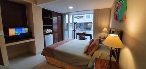 Habitación de hotel con cama y TV en Departamento Caseros Salta en Salta
