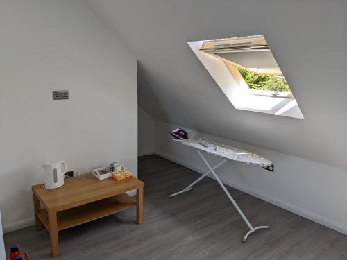 a room with a table and a skylight at 32 in Ashford