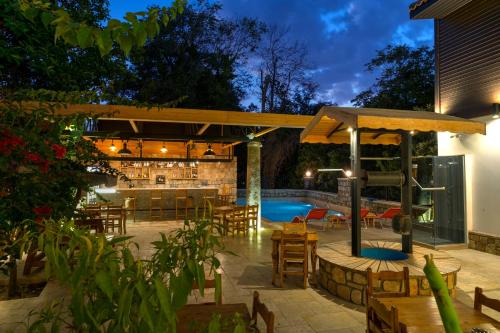 a patio with a bar and a swimming pool at night at Kosa boutique hotel in Antalya