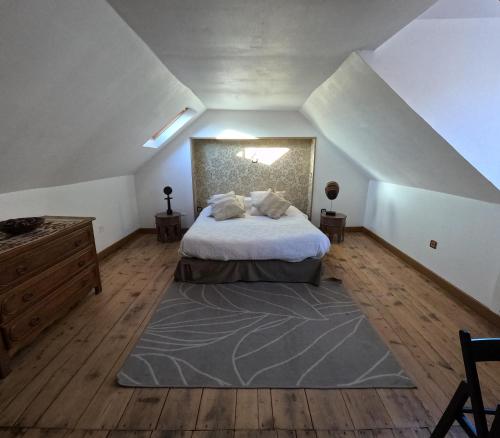 Schlafzimmer im Dachgeschoss mit einem Bett und Holzboden in der Unterkunft VIEUX LOGIS in Vervins