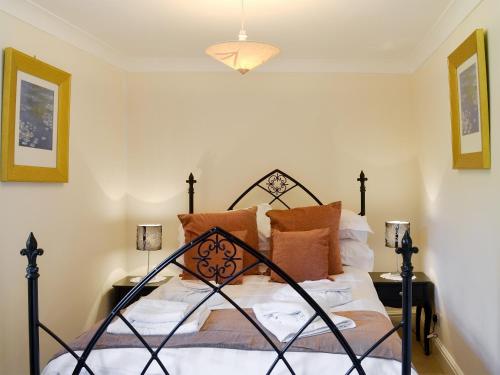 a bedroom with a bed with orange pillows at Boothby Cottage in Willoughby