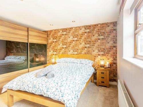 a bedroom with a bed and a brick wall at Church View in Barmby on the Marsh