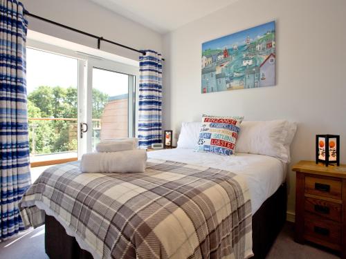 a bedroom with a bed and a large window at Dunlin 4 - The Cove in Brixham