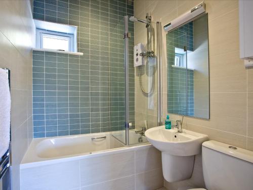a bathroom with a sink and a tub and a toilet at Dunlin 4 - The Cove in Brixham