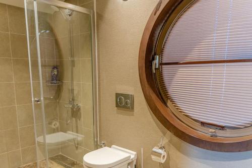 a bathroom with a shower and a toilet and a mirror at Enjoy playing golf, stay where luxury meets peace. in Bodrum City