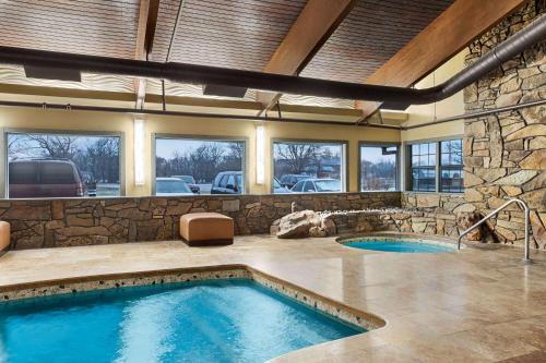 a large indoor pool with a stone wall at Travelodge by Wyndham Coffeyville in Coffeyville