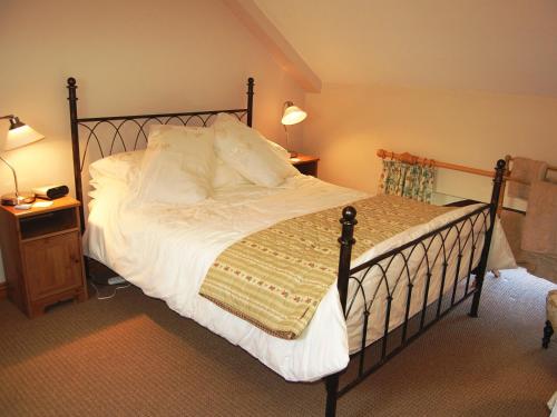 ein Schlafzimmer mit einem großen Bett mit weißer Bettwäsche und Kissen in der Unterkunft Elseghyll Barn in Melmerby