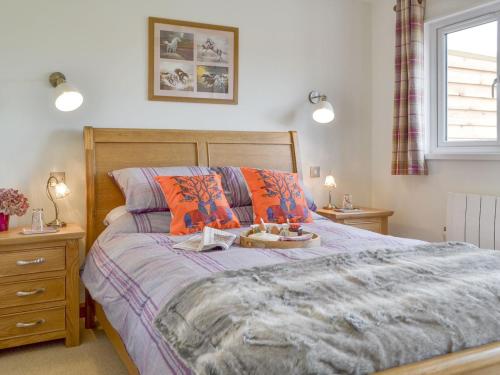 a bedroom with a bed with a tray of food on it at Cedar Lodge in Herstmonceux