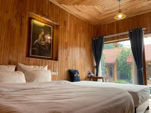 una camera da letto con un letto e un quadro sul muro di My Tam Coc Bungalow a Ninh Binh